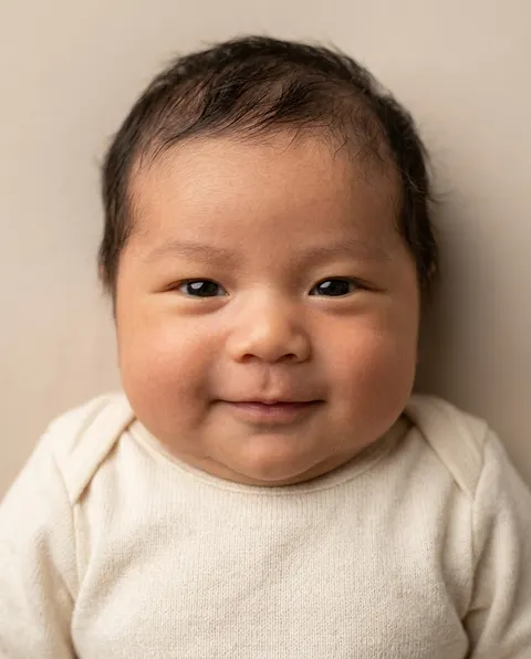 Pasgeboren baby van een mama met Aziatische trekken en een papa met een getinte huid en baard